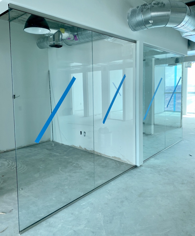 Frameless glass office wall under construction