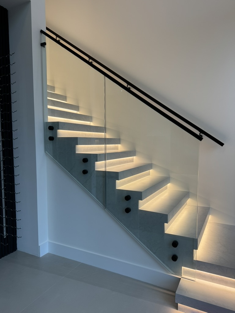 Glass stair railing with standoff system and LED-lit steps