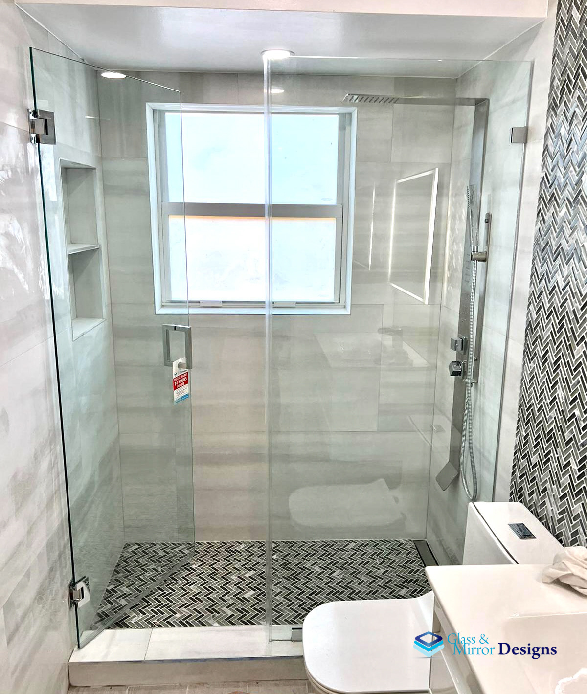 Frameless shower enclosure with window and herringbone floor