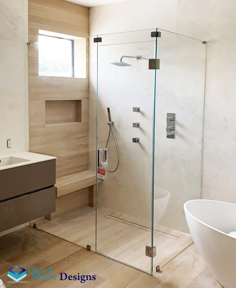 Frameless corner shower enclosure with chrome hinges