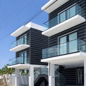 Exterior glass balcony railing with clear tempered glass and matte black hardware.
